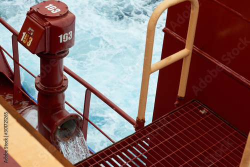 View of Ballast Water exchange process onboard of a ship using flow-through method underway in open ocean. Overflow method through ballast tank air head.
