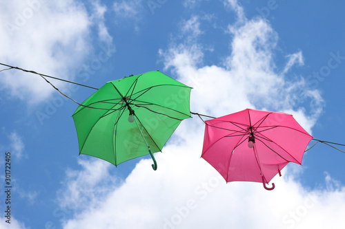 Colorful umbrellas against the blue sky and clouds