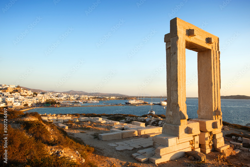 Golden sun paints the classical Portara arch at Temple of Apollo in Naxos, Greece