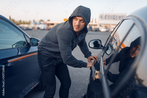 Car thief breaking door lock, criminal lifestyle
