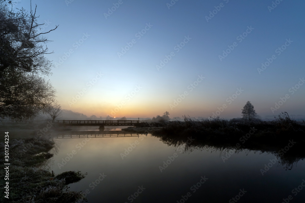 Fototapeta premium A beautiful sunrise over the misty river.