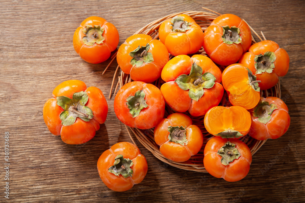 ripe persimmon fruit on a wooden board, top view ripe persimmon fruit on a wooden board, top view