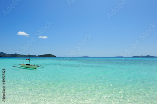 Filipino traditional boat, idyllic "vacations" seascape with beautiful weather, blue sky and clear water.