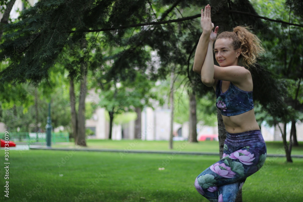 Girl with curly blond hair doing yoga outdoors in the park. Girl with curly blond hair doing yoga outdoors in the park.