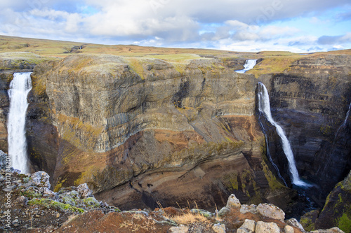 Panorama of colorful gorge with four waterfalls Haifoss, the fourth highest waterfall(122m) of the island, and Granni. The viewpoint on the sheer cliffs at the edge of canyon.. photo