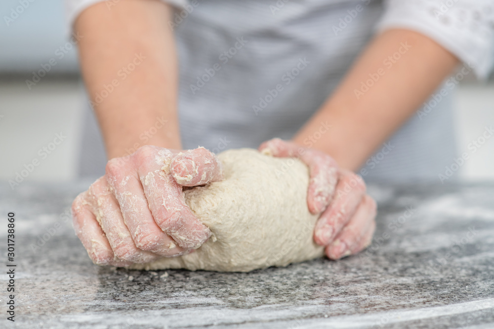 Female hands making dough in the kitchen at home