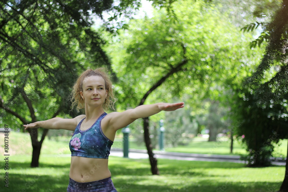 Girl with curly blond hair doing yoga outdoors in the park. Girl with curly blond hair doing yoga outdoors in the park.