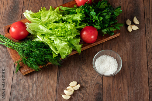 Ingredients for making salad, fresh vegetables on a wooden background.