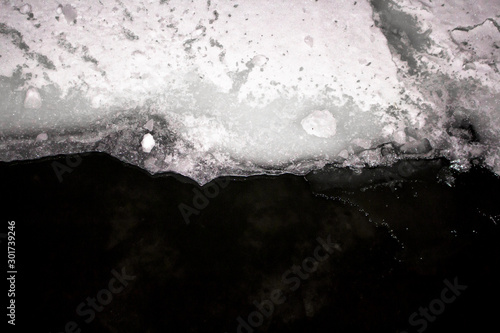 Ice layer covering the surface of dark water