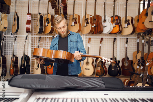 Guitarist puts guitar in the case, music store