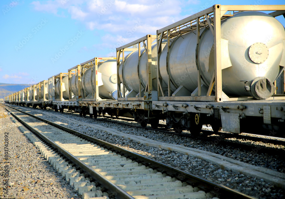 white freight train wagons having oil tankers waiting on the rails white freight train wagons having oil tankers waiting on the rails
