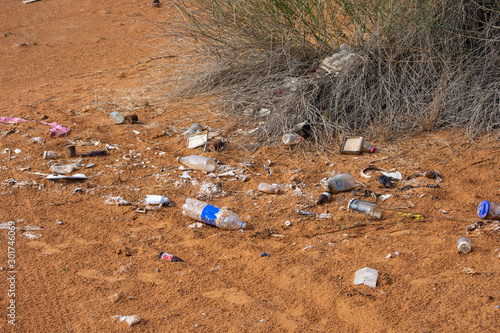 Plastic pollution in the desert sand. Need for awareness of enviornmental protection, recycling, and protecting the world. Environmental concept.