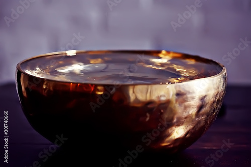 Tablou pe pânză clear water in a golden bowl / clear water in a yellow iron bowl