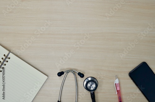 flat layout of book, stethoscope, pen, and smart phone on the wooden table photo