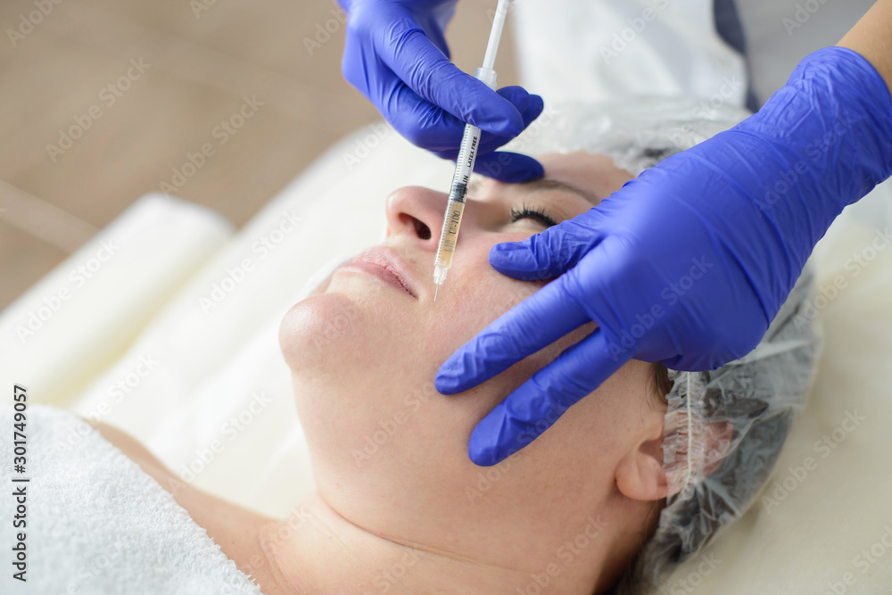 Needle mesotherapy in beauty spa salon or clinic. Cosmetics been injected to woman's face, close up portrait Needle mesotherapy in beauty spa salon or clinic. Cosmetics been injected to woman's face, close up portrait