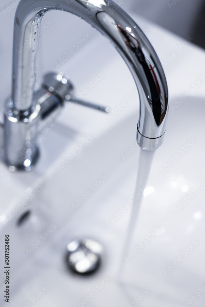 Saving water: Close up of spigot with clear, flowing water Saving water: Close up of spigot with clear, flowing water