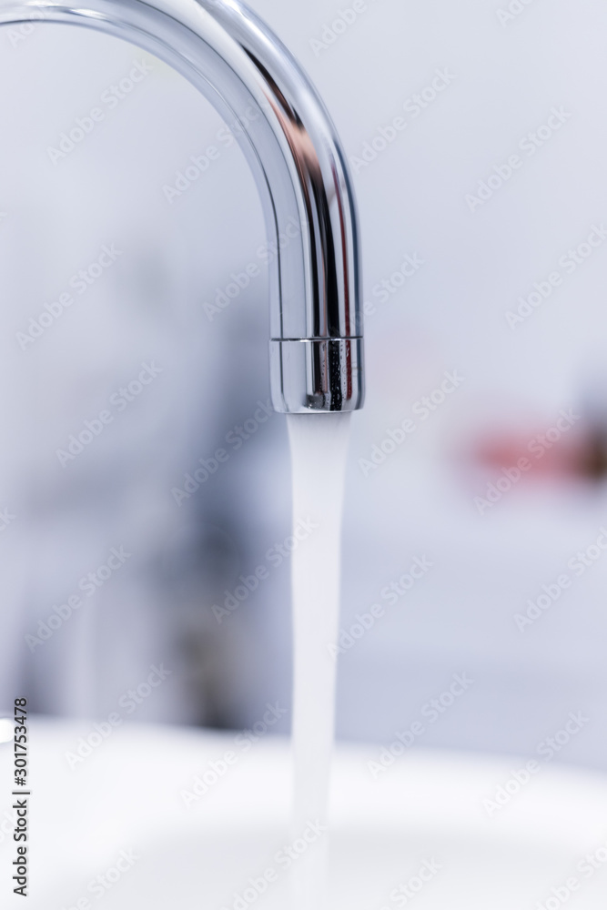Saving water: Close up of spigot with clear, flowing water Saving water: Close up of spigot with clear, flowing water