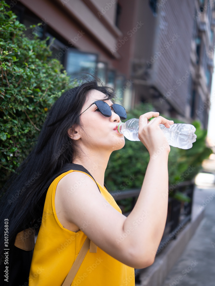 Asian tourist woman drinking a bottle of water in Hua Hin city, travel concept. Asian tourist woman drinking a bottle of water in Hua Hin city, travel concept.