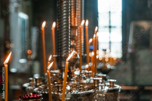 Wedding accessories and interior in Saint Trinity Orthodox Convent including two candlesticks with many candles, flowers, icons and Holy Bible. Wonderful church in Riga, Latvia