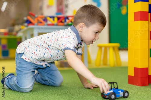 Children play with educational toys. Children sit on the carpet in the playroom at home or in the kindergarten.boy with toy cars