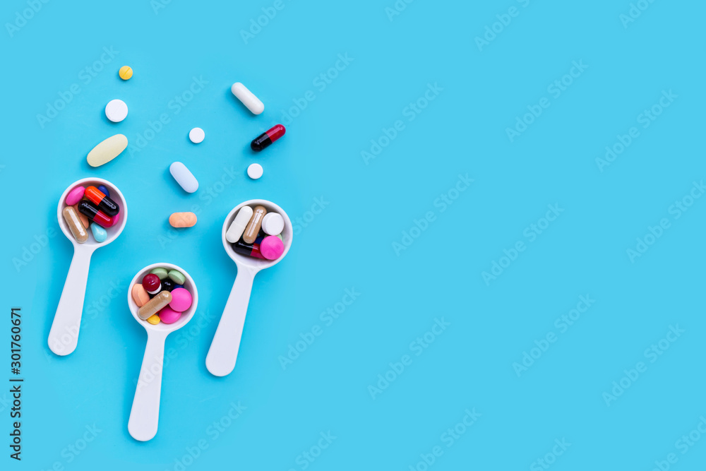 Colorful medicine pills, tablets and capsules on blue background Colorful medicine pills, tablets and capsules on blue background