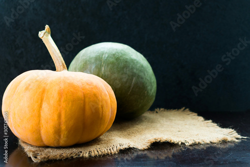  Two green and orange pumpkins on a black background. Copy space. photo