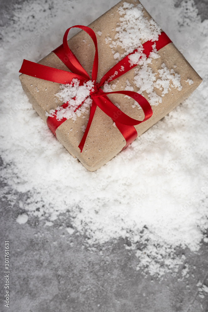 Brown gift boxes tied with red ribbons placed on snow and cement floors. Christmas, New Year, Valentine's, Birthday and special occasions. Brown gift boxes tied with red ribbons placed on snow and cement floors. Christmas, New Year, Valentine's, Birthday and special occasions.