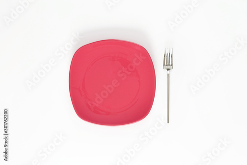  Empty Light Blush Red color plate and fork next to it. Isolated object - on white background