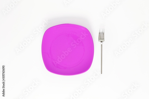 Empty Magenta color plate and fork next to it. Isolated object - on white background 