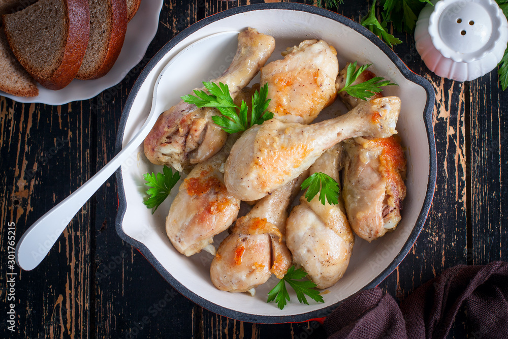 Fried chicken drumsticks in a pan on a wooden table, top view, selective focus Fried chicken drumsticks in a pan on a wooden table, top view, selective focus