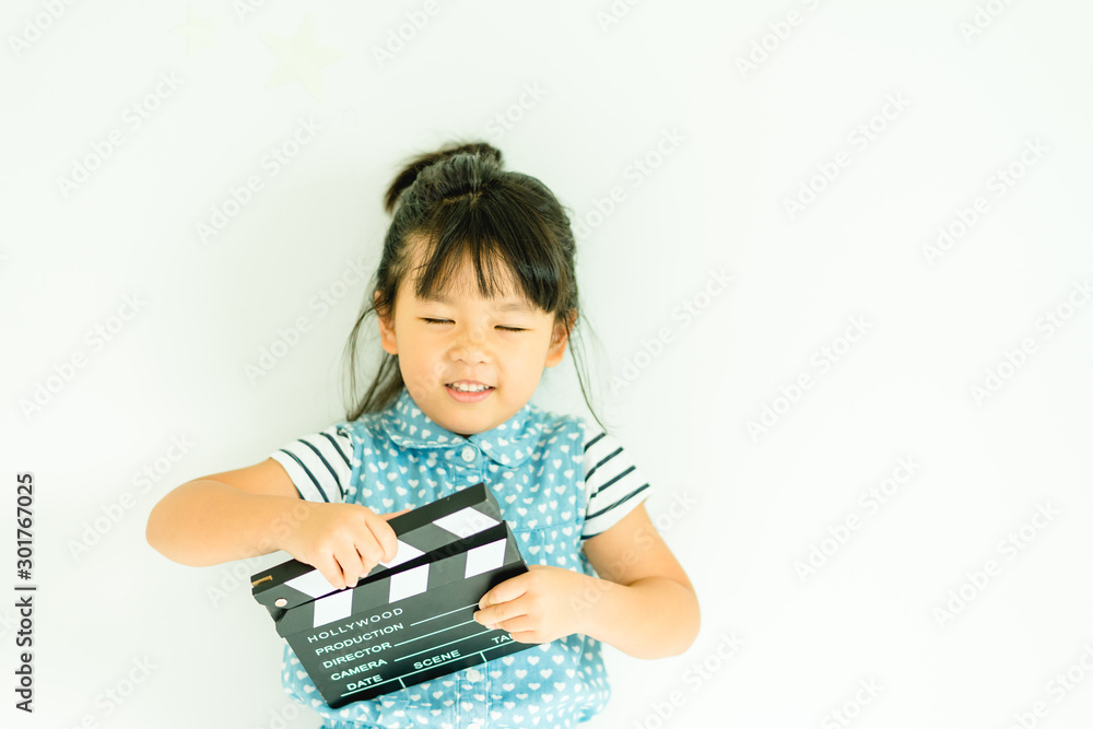 Little asian girl hands holding clapper board for making video cinema in studio.Kids Movie production with clapper board or slate film concept.isolated on white background. Little asian girl hands holding clapper board for making video cinema in studio.Kids Movie production with clapper board or slate film concept.isolated on white background.