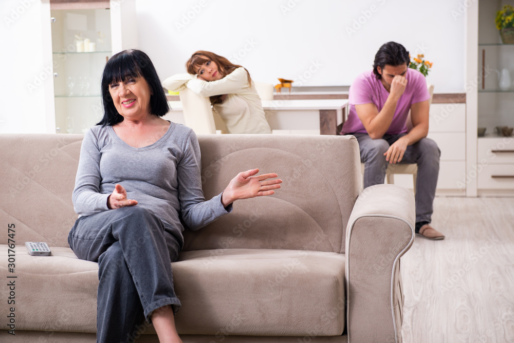 Young family and mother-in-law in family issues concept Young family and mother-in-law in family issues concept
