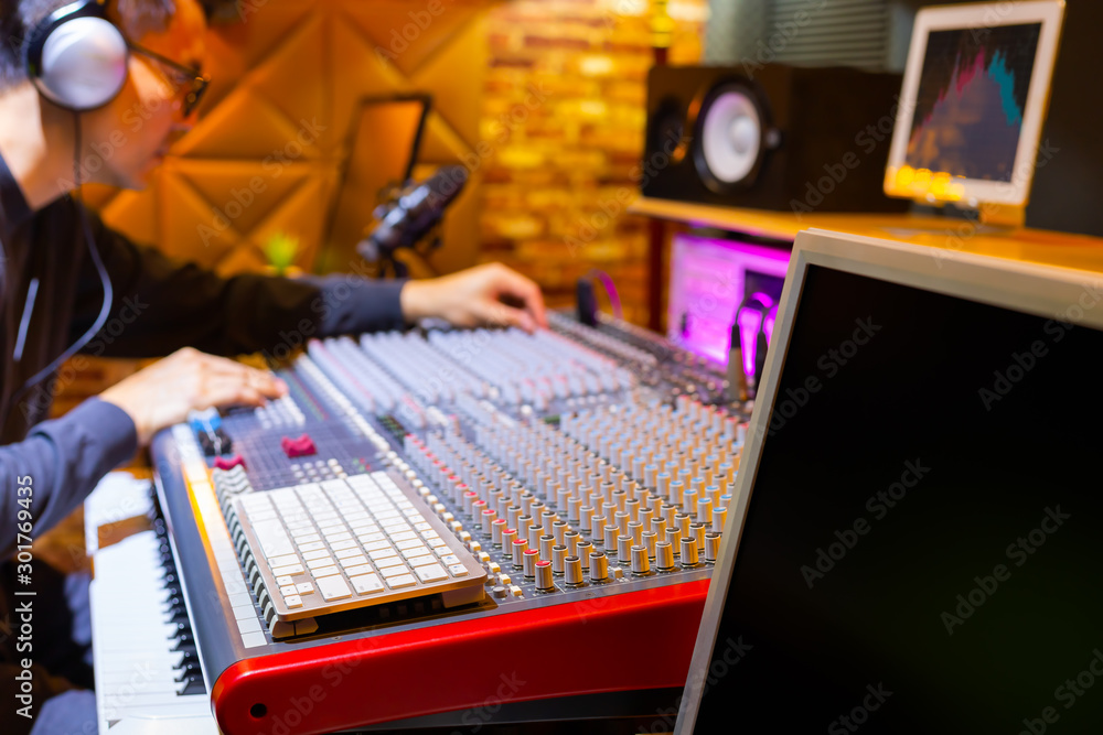 asian male professional music producer, sound engineer mixing a song on ...