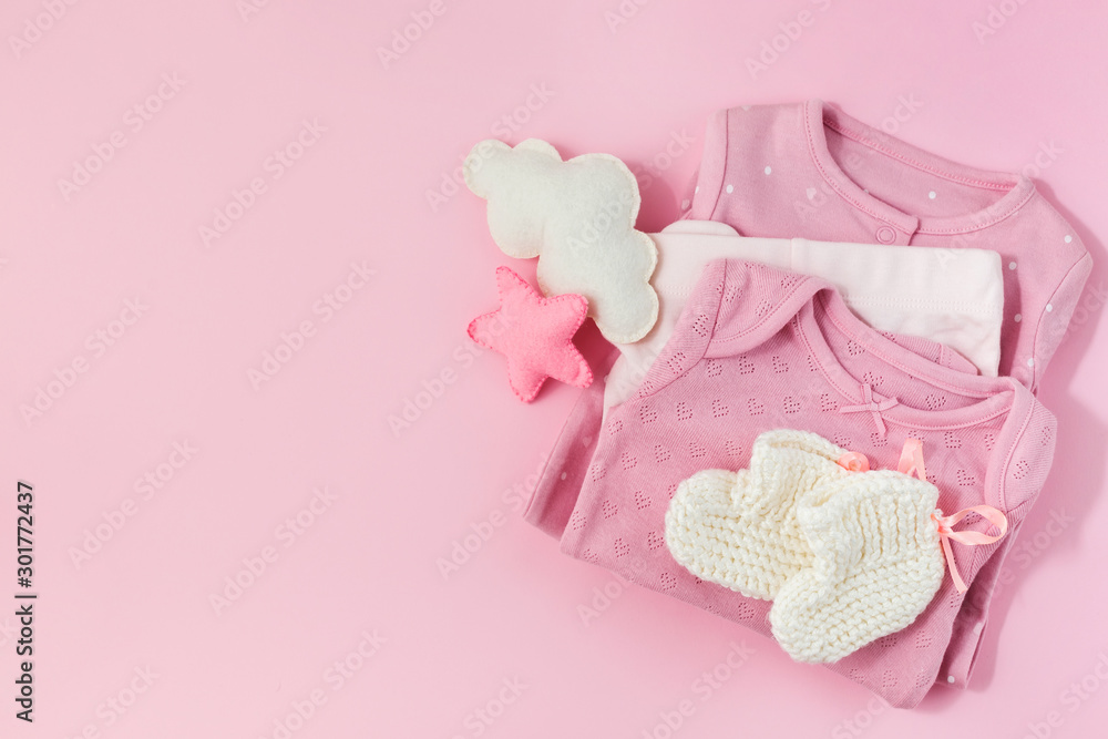 Pink background with clothes, socks and toys for a newborn girl. Pink background with clothes, socks and toys for a newborn girl.