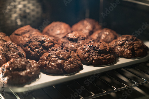 Foto chocolate muffins baking in a modern oven