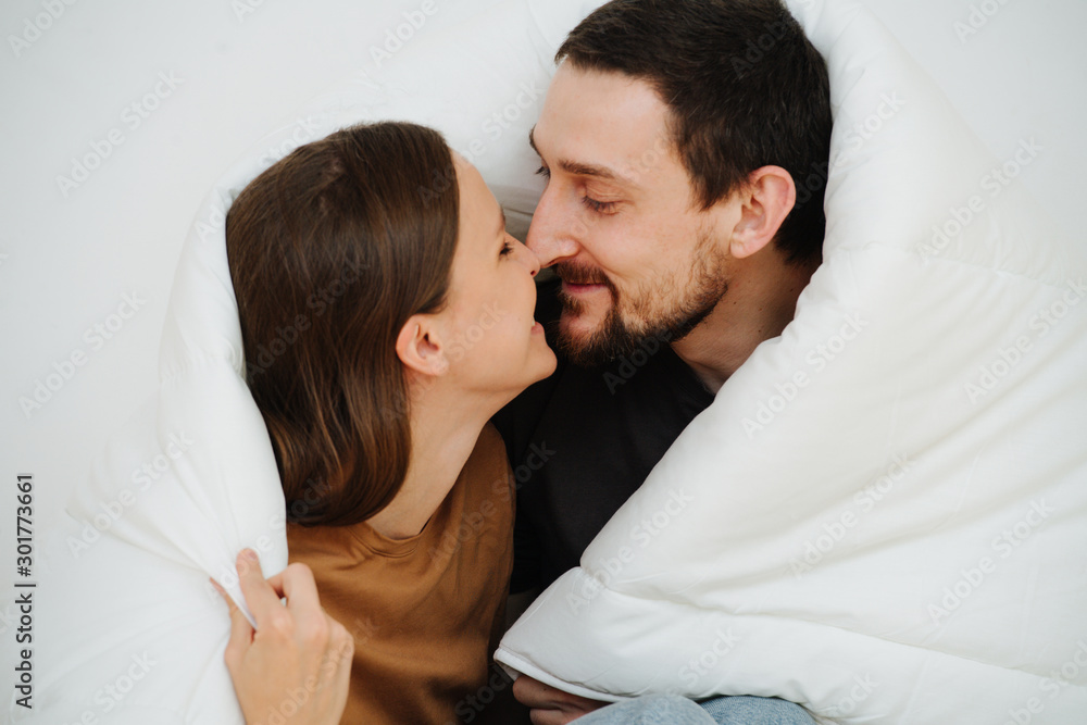 Close up portrait of a middle age couple sitting wrapped in a blanket, kissing Close up portrait of a middle age couple sitting wrapped in a blanket, kissing