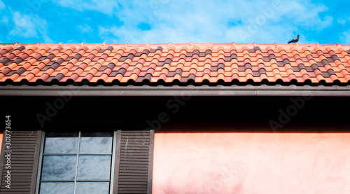 roof top on sky background. Close up of brown clay roof tiles. Red old dirty roof. Old roof tiles. Close-up aerial view of the traditional red Mediterranean roofs with blue summer sky in the old town