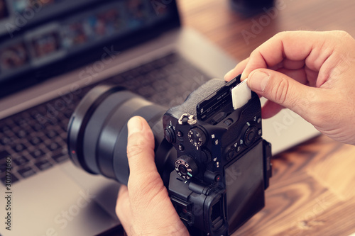 Photographer inserting or removing a memory card in professional camera  photo