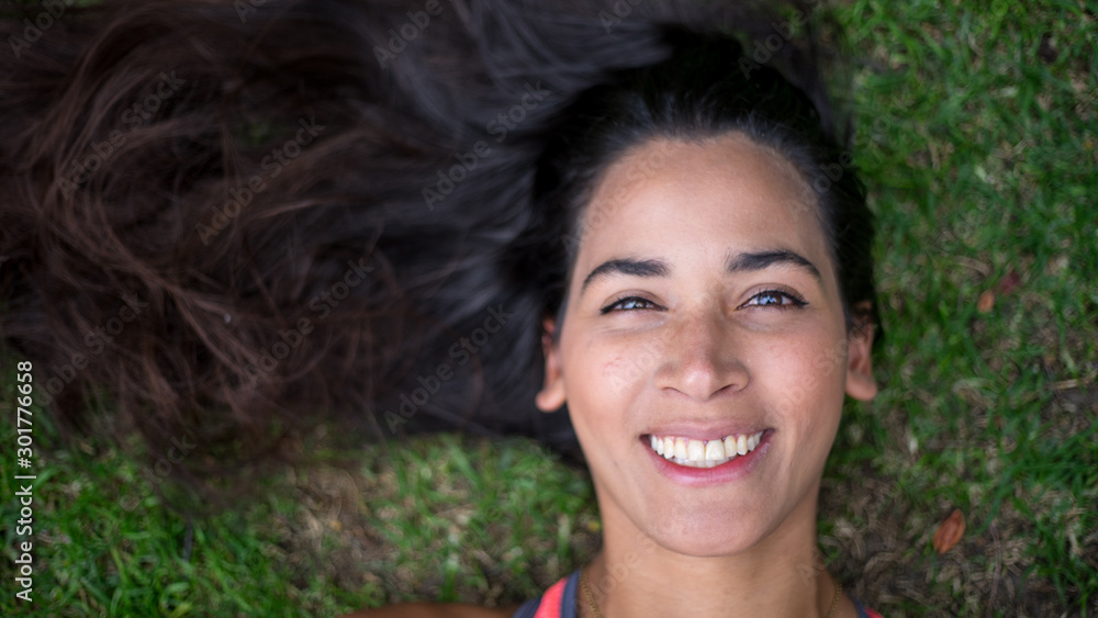 Fototapeta premium beautiful portrait of woman lying on the grass