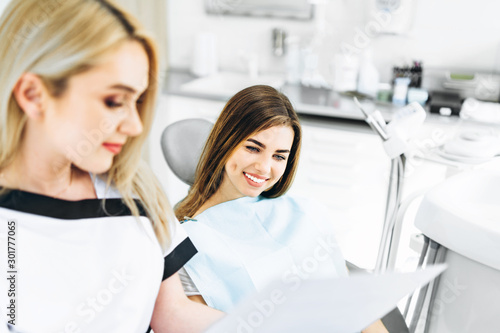 Dentist showing x-ray for the patient and explaining plan of treatment.