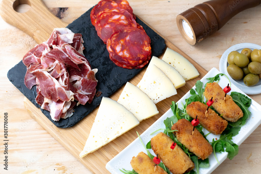 Typical Spanish food consisting of croquettes, Manchego cheese, chorizo and olives Typical Spanish food consisting of croquettes, Manchego cheese, chorizo and olives