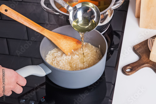 Canvas-taulu Process of adding broth while cooking risotto