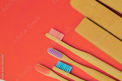 Colorful bamboo toothbrush on red background. Zero waste. Eco friendly solutions 