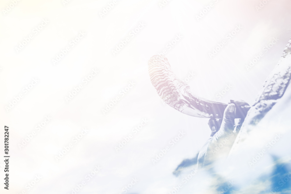 Obraz premium Jewish man in Tallit blowing the Shofar (horn) of Rosh Hashanah (New Year Jew) and Yom Kippur festival.Yom kippur Religious and Holidays symbol concept.