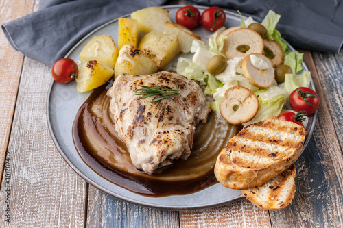 Homemade food. Turkey fillet with teria yaki sauce, fried potatoes, salad with mozzarella cheese, cherry tomatoes and bread chips. Close-up photo