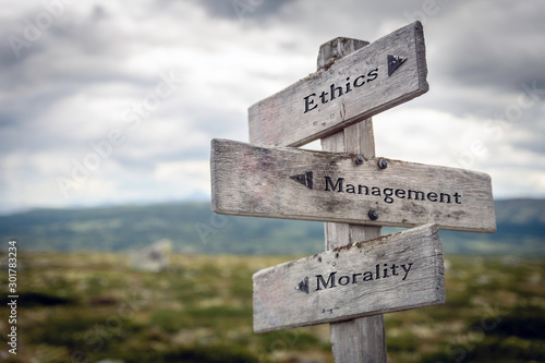 Ethics, management and morality text on wooden sign post outdoors in landscape scenery. Business, quotes and motivational theme concept.