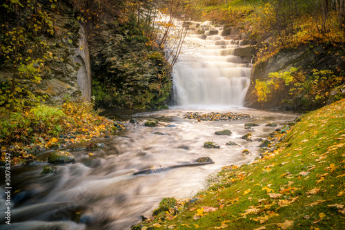 Waterfall cascade in a park in the city of Trondheim. Tourist attraction. Golden Norway in autumn.