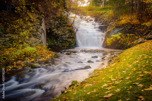 Waterfall cascade in a park in the city of Trondheim. Tourist attraction. Golden Norway in autumn.
