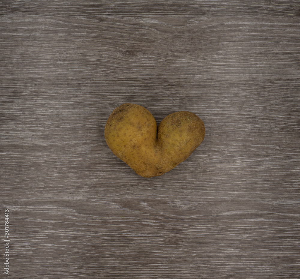 Obraz premium Potato heart on a wooden table