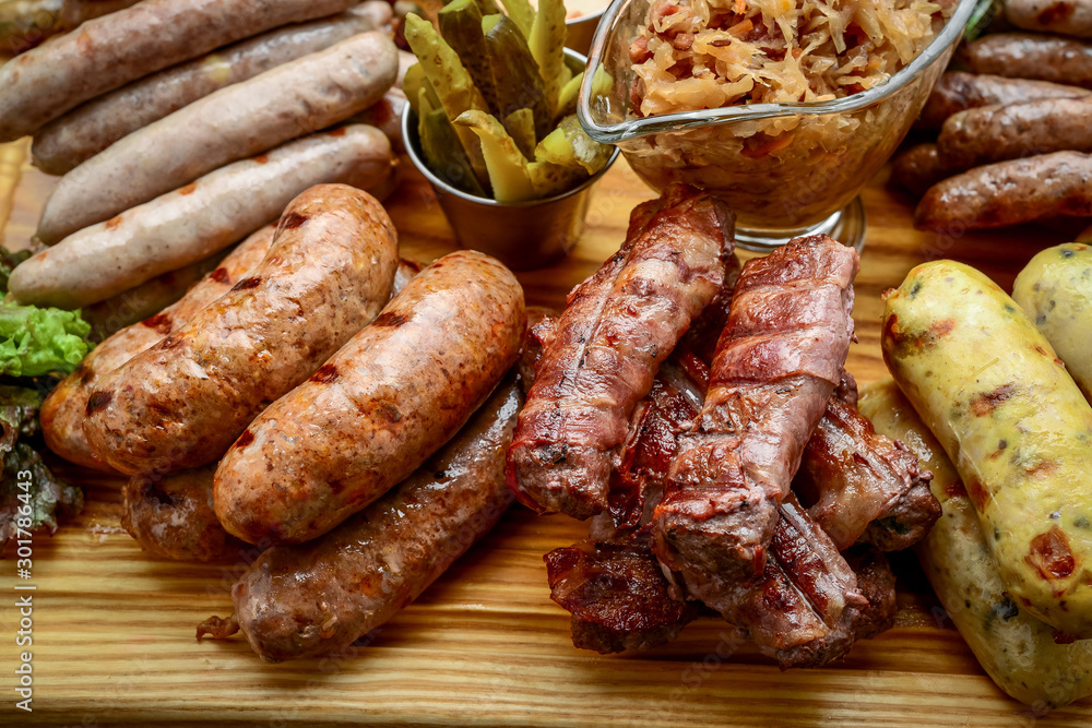 Grilled sausages with glass of beer on a wooden table